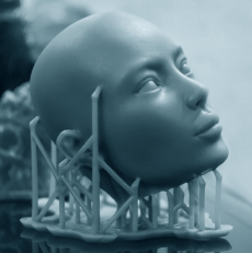 Stilisierter, glatter menschlicher Kopf aus 3D-Druckharz, nach oben rechts blickend, mit feinen Gesichtszügen und sichtbaren Gitter‑Stützstrukturen an der Basis.