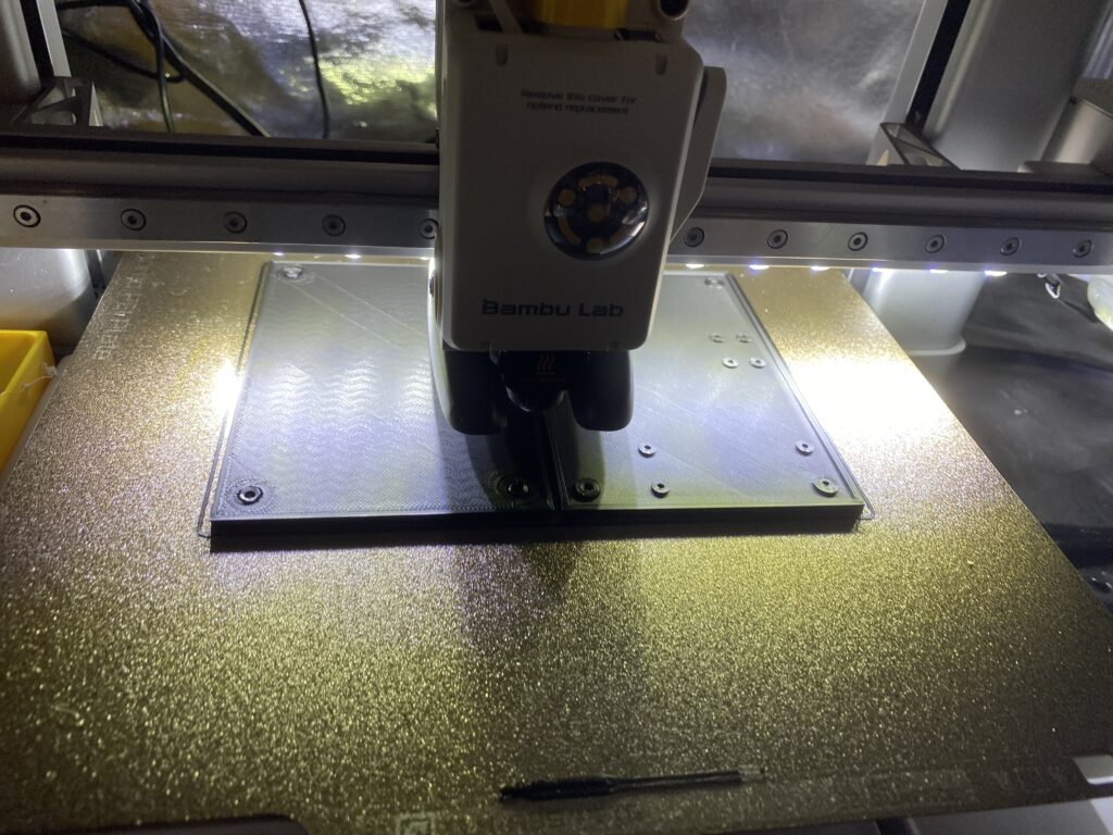 3D-Druck-Station mit Kopf von „bambu Lab“ über einer Metallplatte im Aufbaubereich